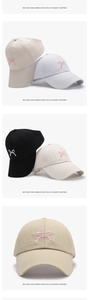 Detailed embroidery of pink bow on a cotton baseball cap with elegant textures