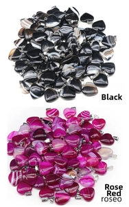 Dettaglio macro di pendenti a cuore in agata striata nera e rosa con ganci in argento