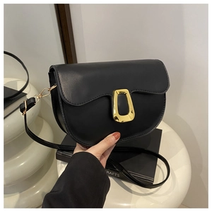 Detail of a black PU leather saddle bag featuring a stylish golden trapezoid buckle