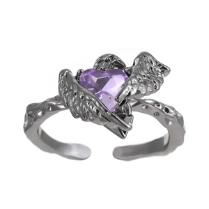 Detail of gothic silver ring with purple heart stone and intricate feather wings