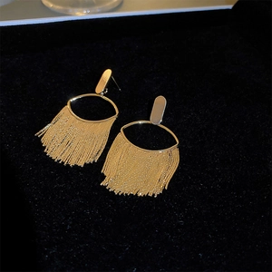 Elegant gold metal tassel earrings with vintage floral elements on black velvet