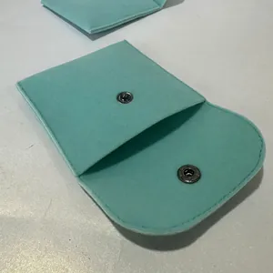 Macro detail of mint green velvet jewelry pouch with silver metal snap button closure