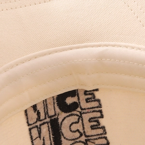Macro detail of high-quality cotton sweatband and NICE embroidery on beige kids baseball cap