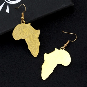 Détail de boucles d'oreilles carte d'Afrique dorées avec gravure de l'Œil d'Horus