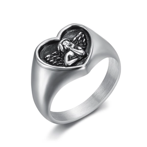 Polished silver heart ring with embossed angel design on minimalist white background