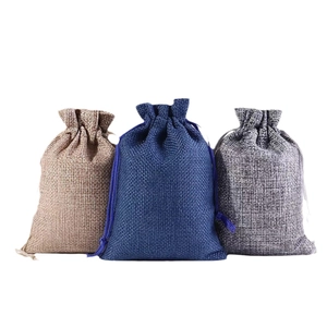 Three linen Christmas drawstring gift bags in light brown, dark blue, and grey colors