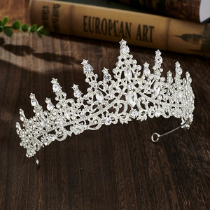 Detailed view of silver crystal bridal crown on a wooden table with art book background