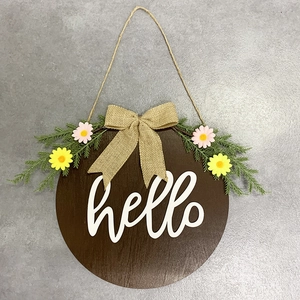 Close-up of hello wooden welcome sign with burlap bow and faux greenery