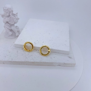 Detail view of gold lobster clasp with micro-set cubic zirconia on a white stone base
