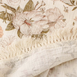 Detail of soft cotton crepe fabric with vintage floral print and delicate tassels