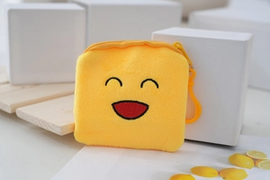 Detail of yellow plush coin purse with embroidered smiley face and sturdy plastic hook