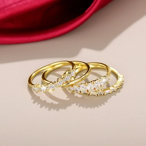 Macro-opname van drie vergulde ringen met zirkonia op een elegante zijden achtergrond