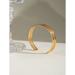 Close-up of polished 18k gold-plated stainless steel double-layered open bangle
