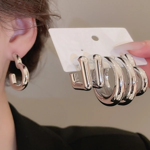 Ensemble de boucles d'oreilles argentées avec puces rondes et carrées sur carte blanche