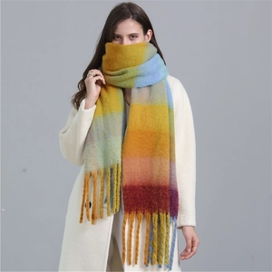 Detail of colorful rainbow plaid scarf featuring long fringes and thick cashmere-like texture