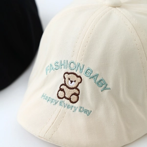 Beige cotton baby flat cap featuring a brown embroidered bear and curved lettering