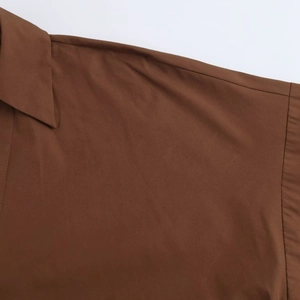 Close-up of deep brown poplin shirt featuring lapel collar and fine stitching details