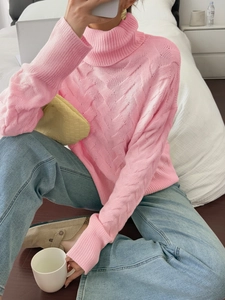 Detailed cable-knit texture on pink turtleneck sweater with long sleeves and soft finish