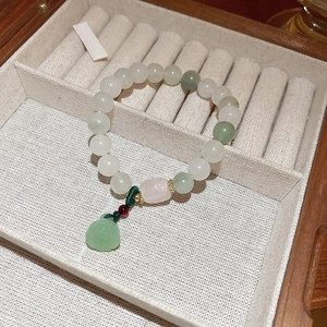 Close-up of elegant French style beaded bracelet with pearls and green lucky charm