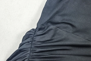 Detail of elegant black ruched stitching on the side of a sleeveless fitted maxi dress