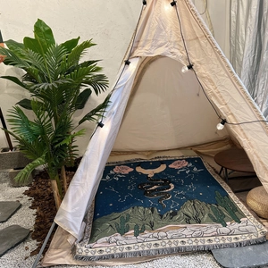 Bohemian woven camping blanket with mystic moon and snake pattern in a cozy tent setup
