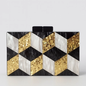 Detail of acrylic clutch bag featuring 3D geometric patchwork in black, white and gold