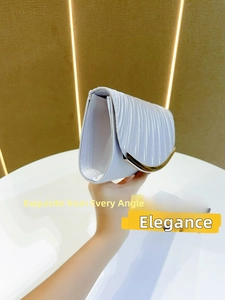 Detail of silver pleated satin evening clutch bag with curved gold metal trim detail