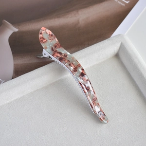 Close-up of tortoise shell acetate shark hair claw clip with gold foil on velvet tray