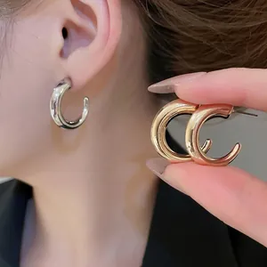 Polished chunky C-shaped hoop earrings in gold and silver finish for a minimalist look