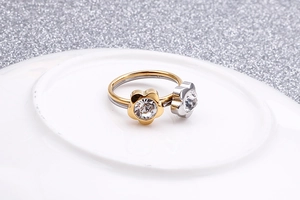 Detailed view of gold and silver flower nose rings with zircons on a white plate