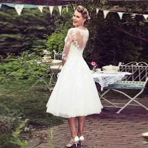 Elegant white tea-length lace wedding dress with sheer long sleeves and tulle skirt