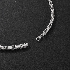 Macro shot of silver Byzantine style stainless steel chain necklace with lobster clasp
