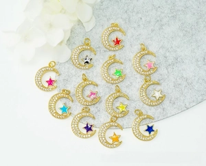 Macro detail of 18K gold plated moon pendants with micro-pave cubic zirconia and colorful enamel