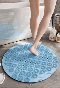 Détail du tapis de bain rond bleu clair en TPE avec ventouses et trous de drainage sous les pieds