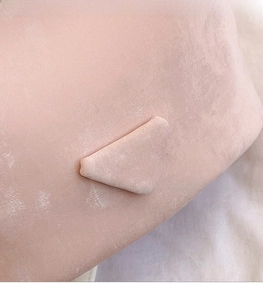 Detailed close-up of pink bucket bag featuring a triangle fashion patch and grainy texture