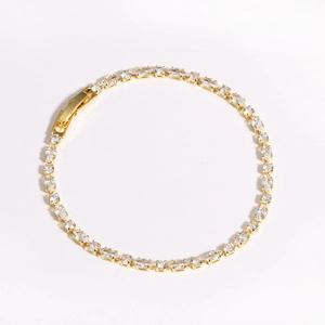 Macro detail of gold tennis bracelet with oval cubic zirconia and fold-over clasp