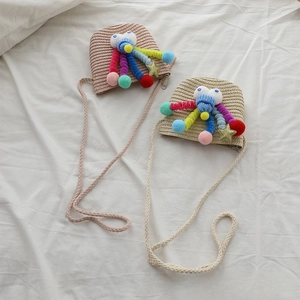 Detailed view of handmade straw crossbody bags with cute cartoon eyes and knit horns