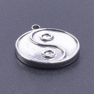 Macro detail of silver Tai Chi Yin Yang pendant in polished 304 stainless steel
