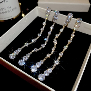 Macro view of long tassel drop earrings with sparkling pear-cut cubic zirconia in box