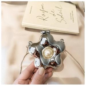 Detail view of flower-shaped mini acrylic bag with silver mirror finish and pearl