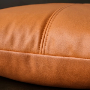 Close-up of brown tech fabric pillow cover showing premium leather texture and stitching