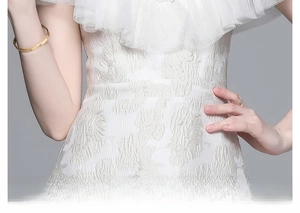 Détail de la robe en jacquard blanc avec tissu texturé et décolleté en tulle plissé