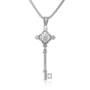 Detail shot of a silver hip hop key pendant with ornate patterns on a box chain