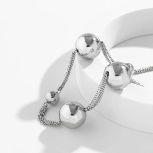 Macro view of multi-strand silver metal chain bracelet with polished oversized round beads