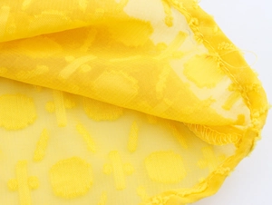 Detailansicht aus gelbem, transparentem Netzstoff mit strukturiertem Jacquard-Muster