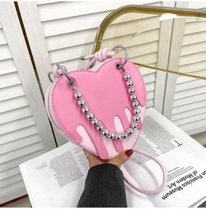 Detail of pink heart-shaped bag featuring melting fluid layers and silver bead chain