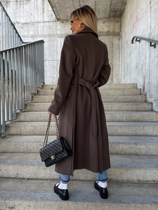Rear view of a long brown wool coat with waist tie belt and slim fit tailoring