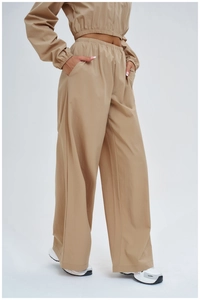 Detail of high-waist loose wide-leg sports pants with elastic waistband and pockets