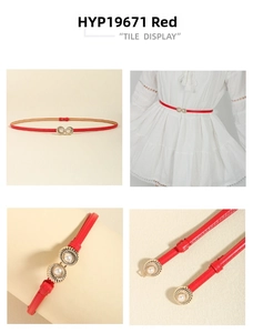 Detail of red thin waist belt featuring a gold shell buckle with a white pearl accent