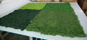Detailed macro texture of artificial silk moss turf in various shades of green colors